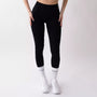 Leggings sportivi neri da donna indossati con fascia alta in vita, morbidi ed elasticizzati.