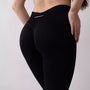 Dettaglio leggings sportivi neri da donna indossati con fascia alta in vita, morbidi ed elasticizzati.