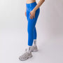 Leggings sportivi blu da donna indossati con fascia alta in vita, morbidi ed elasticizzati.