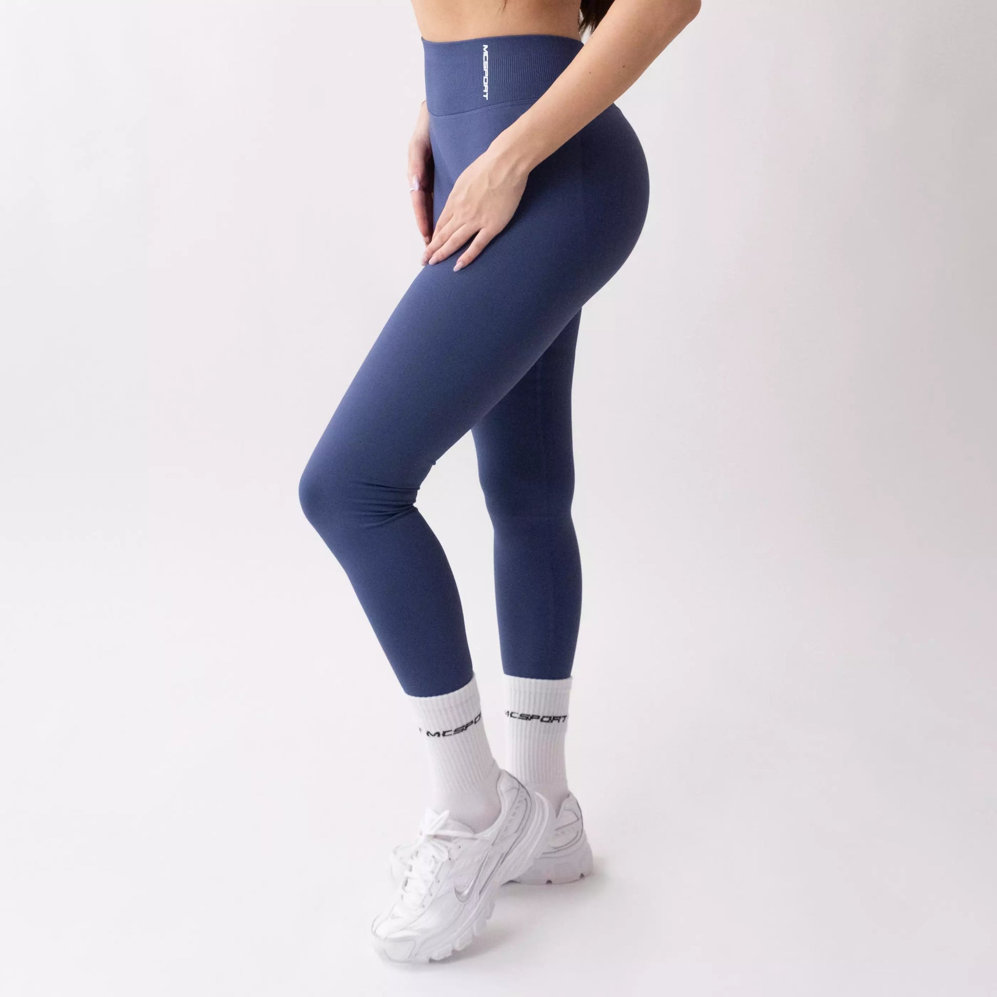 Leggings sportivi denim da donna indossati con fascia alta in vita, morbidi ed elasticizzati.