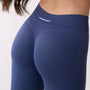 Dettaglio leggings sportivi denim da donna indossati con fascia alta in vita, morbidi ed elasticizzati.