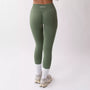 Leggings sportivi verde salvia da donna indossati con fascia alta in vita, morbidi ed elasticizzati.