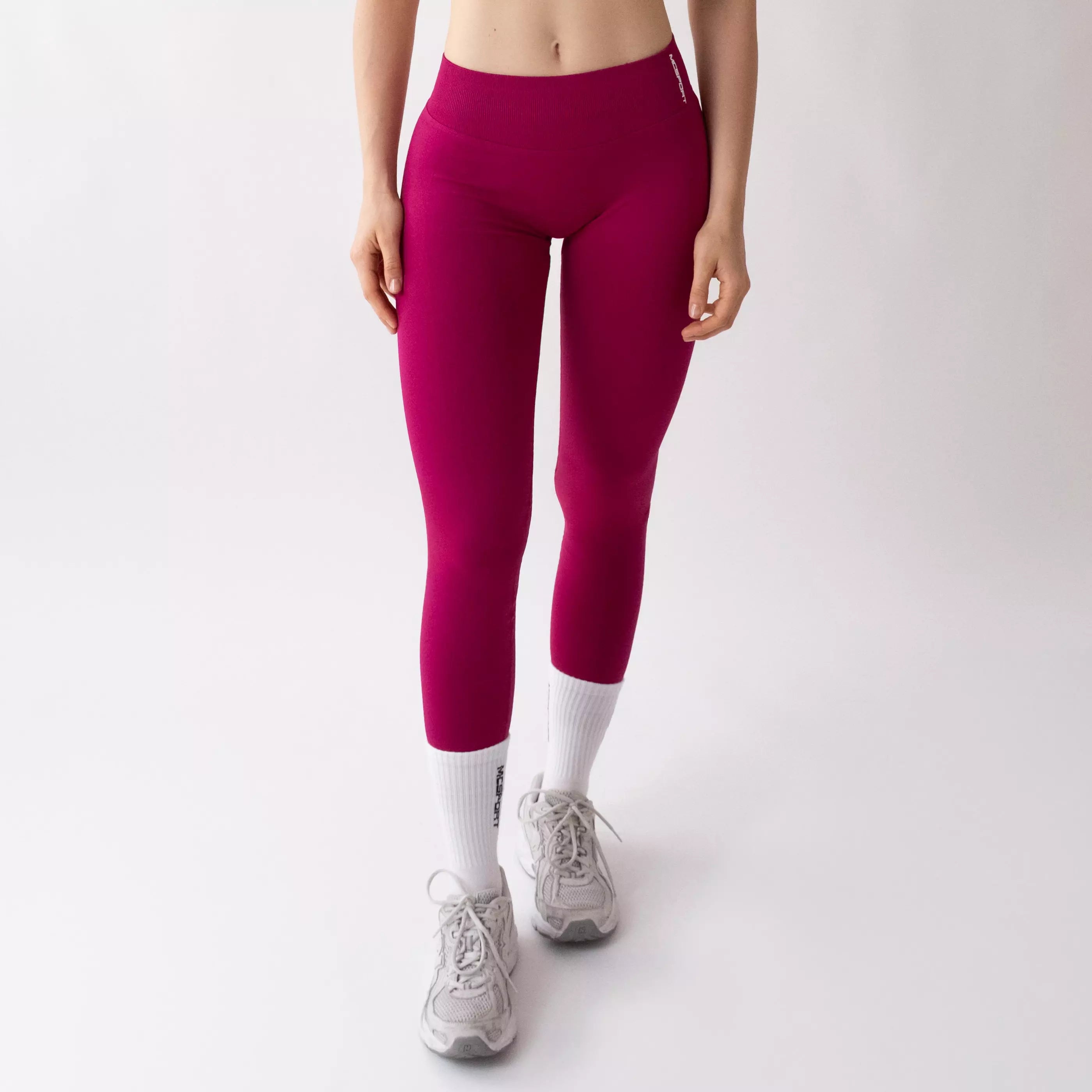 Leggings sportivi color orchidea da donna indossati con fascia alta in vita, morbidi ed elasticizzati.