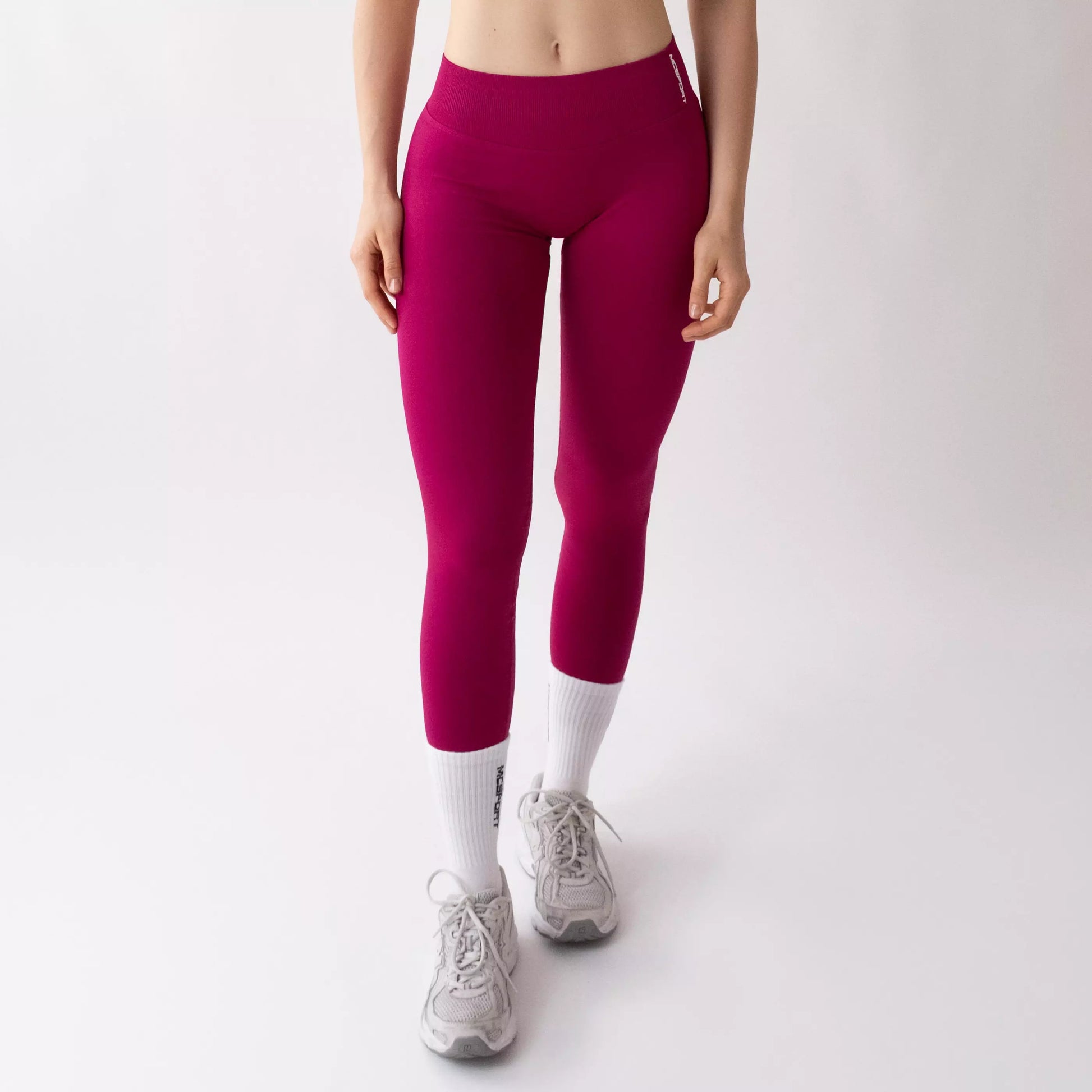 Leggings sportivi color orchidea da donna indossati con fascia alta in vita, morbidi ed elasticizzati.
