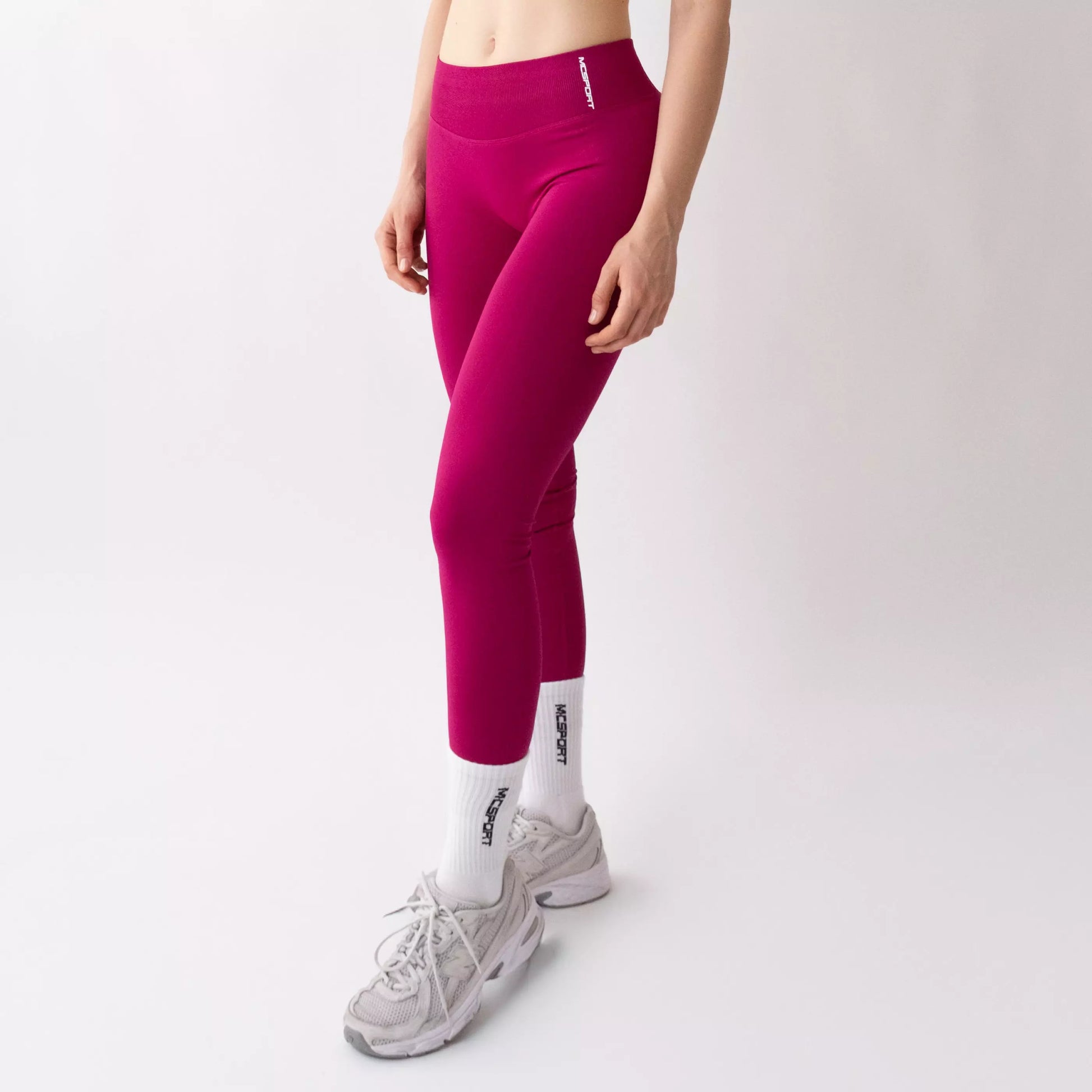 Leggings sportivi color orchidea da donna indossati con fascia alta in vita, morbidi ed elasticizzati.
