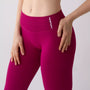 Dettaglio leggings sportivi color orchidea da donna indossati con fascia alta in vita, morbidi ed elasticizzati.