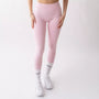 Leggings sportivi rosa da donna indossati con fascia alta in vita, morbidi ed elasticizzati.
