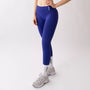 Leggings sportivi viola da donna indossati con fascia alta in vita, morbidi ed elasticizzati.