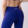 Dettaglio leggings sportivi viola da donna indossati con fascia alta in vita, morbidi ed elasticizzati.