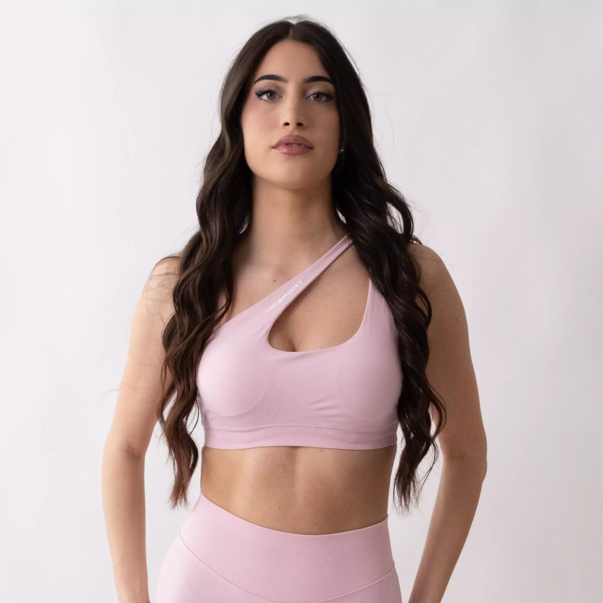 Top sportivo monospalla nero da donna indossato dal design moderno ed essenziale, con supporto confortevole e tessuto elasticizzato. Ideale per fitness, yoga, pilates e allenamenti.