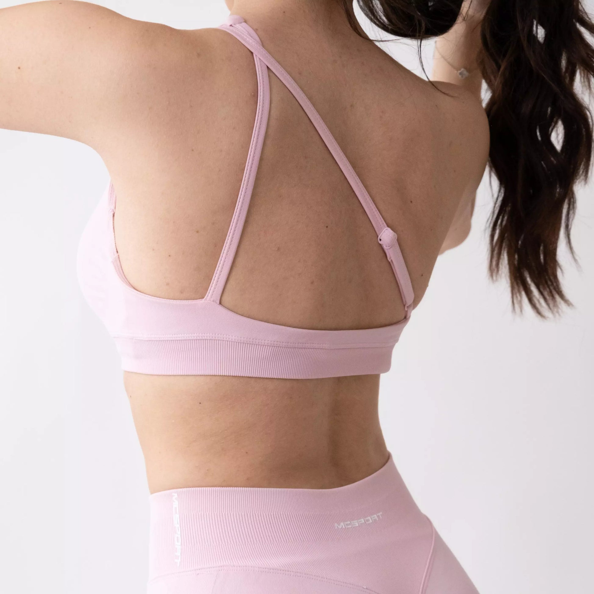 Top sportivo monospalla nero da donna indossato dal design moderno ed essenziale, con supporto confortevole e tessuto elasticizzato. Ideale per fitness, yoga, pilates e allenamenti.