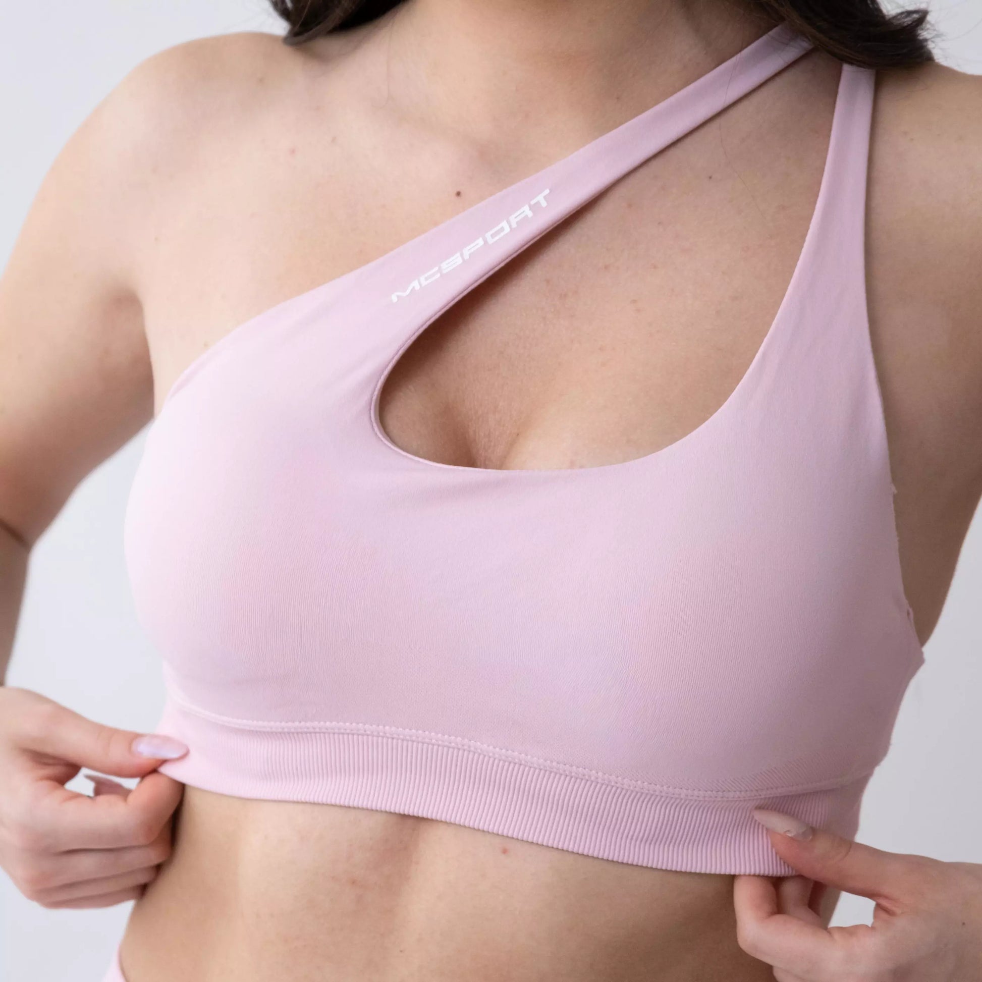 Top sportivo monospalla nero da donna indossato dal design moderno ed essenziale, con supporto confortevole e tessuto elasticizzato. Ideale per fitness, yoga, pilates e allenamenti.