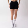 Shorts sportivi neri da donna indossati con fascia alta in vita, morbidi ed elasticizzati.
