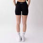 Shorts sportivi neri da donna indossati con fascia alta in vita, morbidi ed elasticizzati.