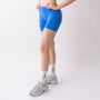 Shorts sportivi blu da donna indossati con fascia alta in vita, morbidi ed elasticizzati.