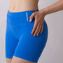 Shorts sportivi blu da donna indossati con fascia alta in vita, morbidi ed elasticizzati.