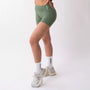 Shorts sportivi verde salvia da donna indossati con fascia alta in vita, morbidi ed elasticizzati.
