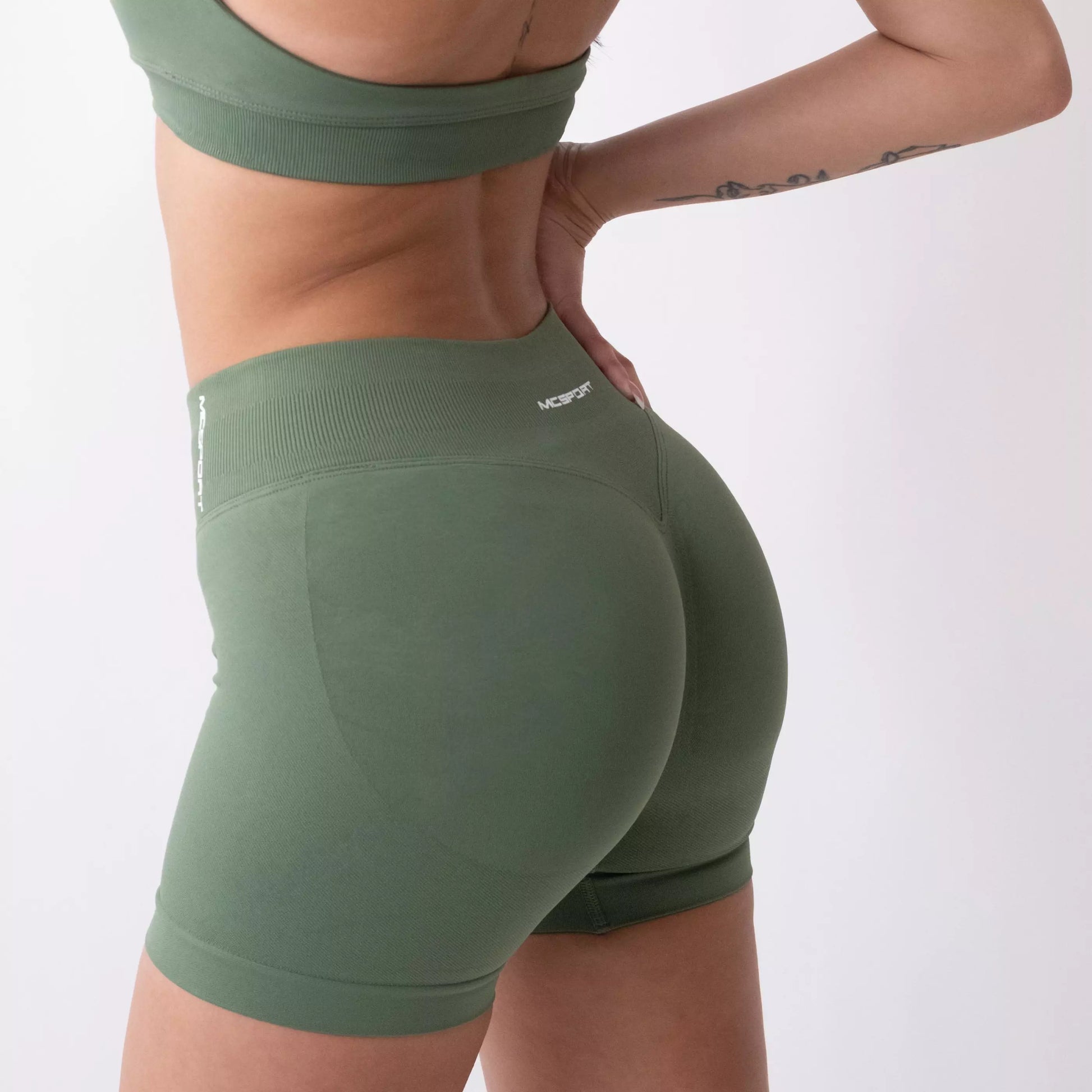 Shorts sportivi verde salvia da donna indossati con fascia alta in vita, morbidi ed elasticizzati.