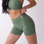 Shorts sportivi verde salvia da donna indossati con fascia alta in vita, morbidi ed elasticizzati.