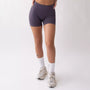 Shorts sportivi grigi da donna indossati con fascia alta in vita, morbidi ed elasticizzati.