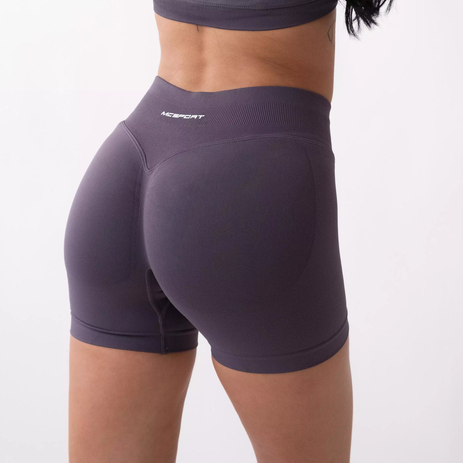 Shorts sportivi grigi da donna indossati con fascia alta in vita, morbidi ed elasticizzati.