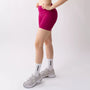 Shorts sportivi color orchidea da donna indossati con fascia alta in vita, morbidi ed elasticizzati.
