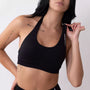Top sportivo nero da donna indossato dal design essenziale e confortevole, ideale per fitness, palestra, yoga e pilates.