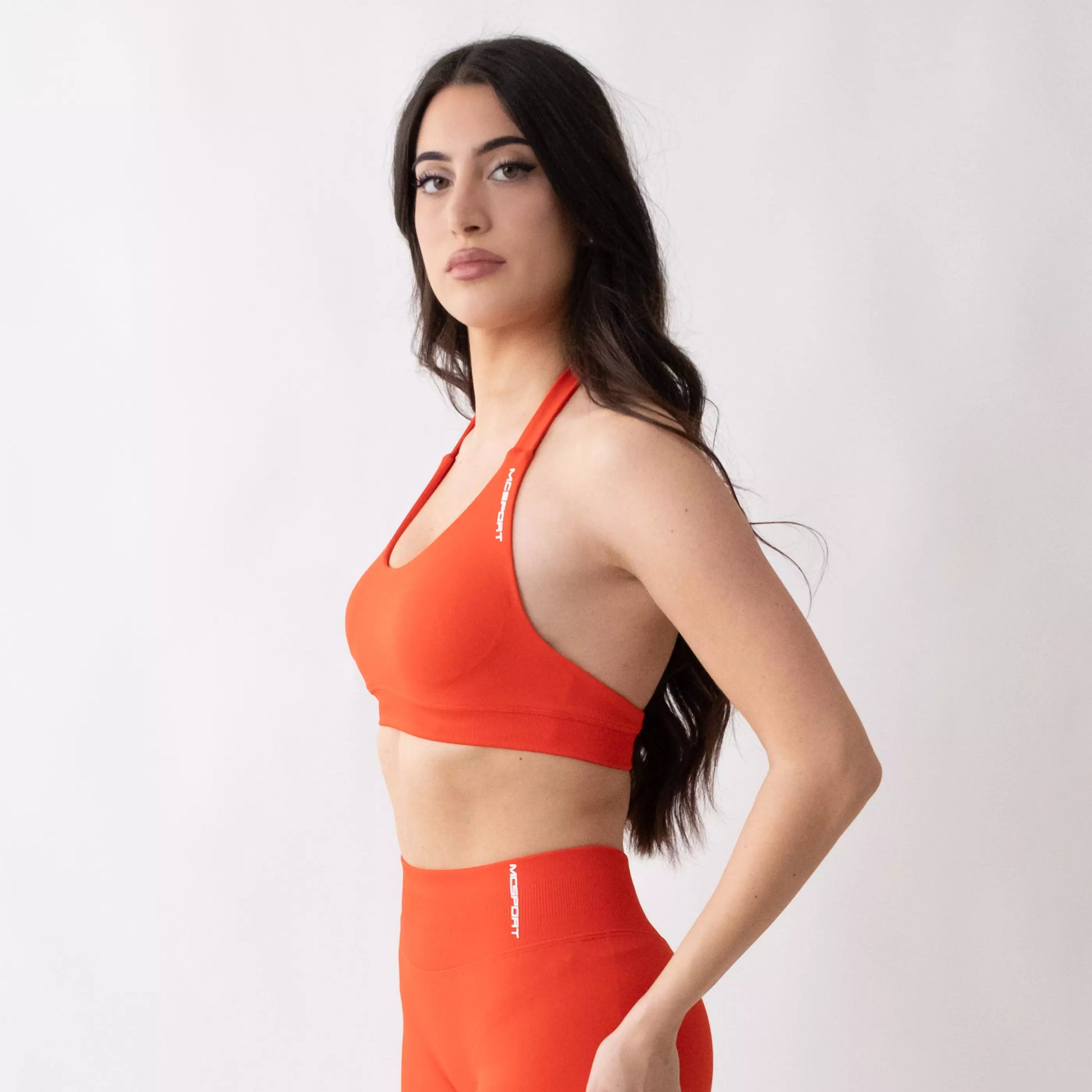 Top sportivo color corallo da donna indossato dal design essenziale e confortevole, ideale per fitness, palestra, yoga e pilates.