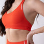 Top sportivo color corallo da donna indossato dal design essenziale e confortevole, ideale per fitness, palestra, yoga e pilates.
