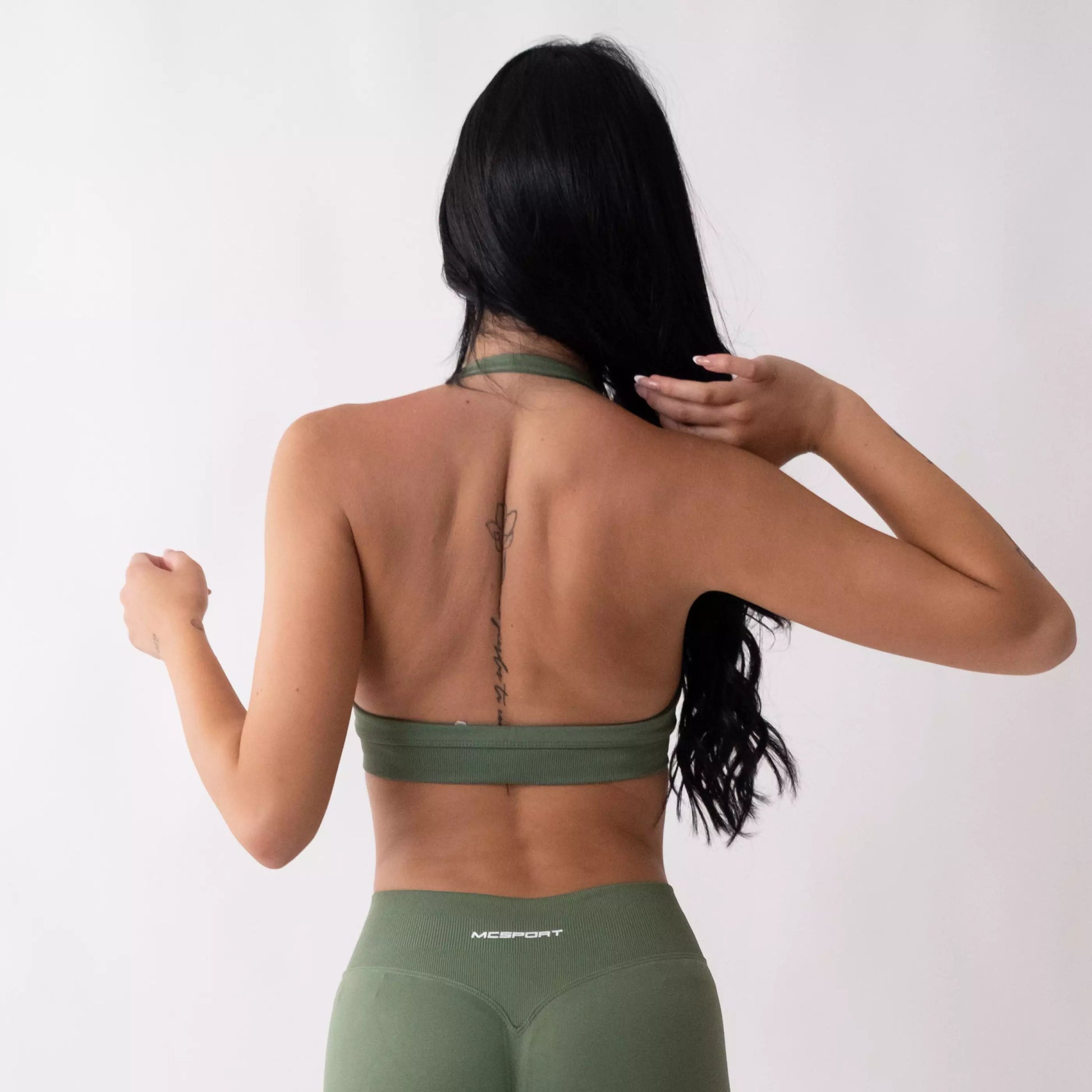 Top sportivo verde salvia da donna indossato dal design essenziale e confortevole, ideale per fitness, palestra, yoga e pilates.