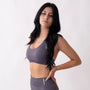 Top sportivo grigio da donna indossato dal design essenziale e confortevole, ideale per fitness, palestra, yoga e pilates. 