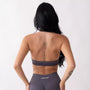 Top sportivo grigio da donna indossato dal design essenziale e confortevole, ideale per fitness, palestra, yoga e pilates. 