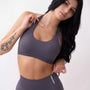 Top sportivo grigio da donna indossato dal design essenziale e confortevole, ideale per fitness, palestra, yoga e pilates. 