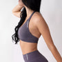 Top sportivo grigio da donna indossato dal design essenziale e confortevole, ideale per fitness, palestra, yoga e pilates. 
