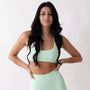 Top sportivo monospalla color menta da donna indossato dal design moderno ed essenziale, con supporto confortevole e tessuto elasticizzato. 