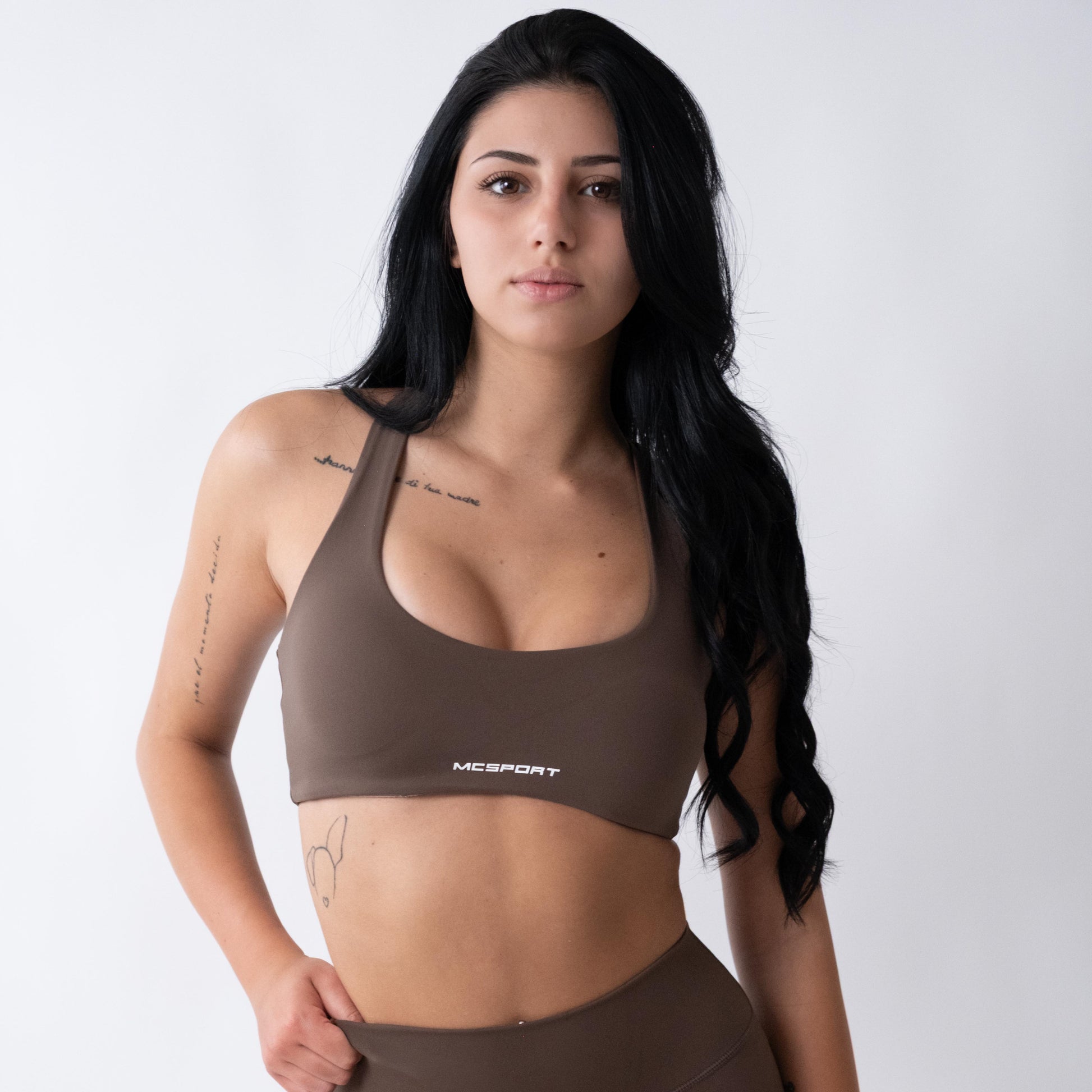 Top sportivo marrone da donna indossato con schiena olimpionica: tessuto elasticizzato, supporto confortevole e libertà di movimento per fitness, yoga, pilates e allenamenti.