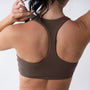 Top sportivo marrone da donna indossato con schiena olimpionica: tessuto elasticizzato, supporto confortevole e libertà di movimento per fitness, yoga, pilates e allenamenti.