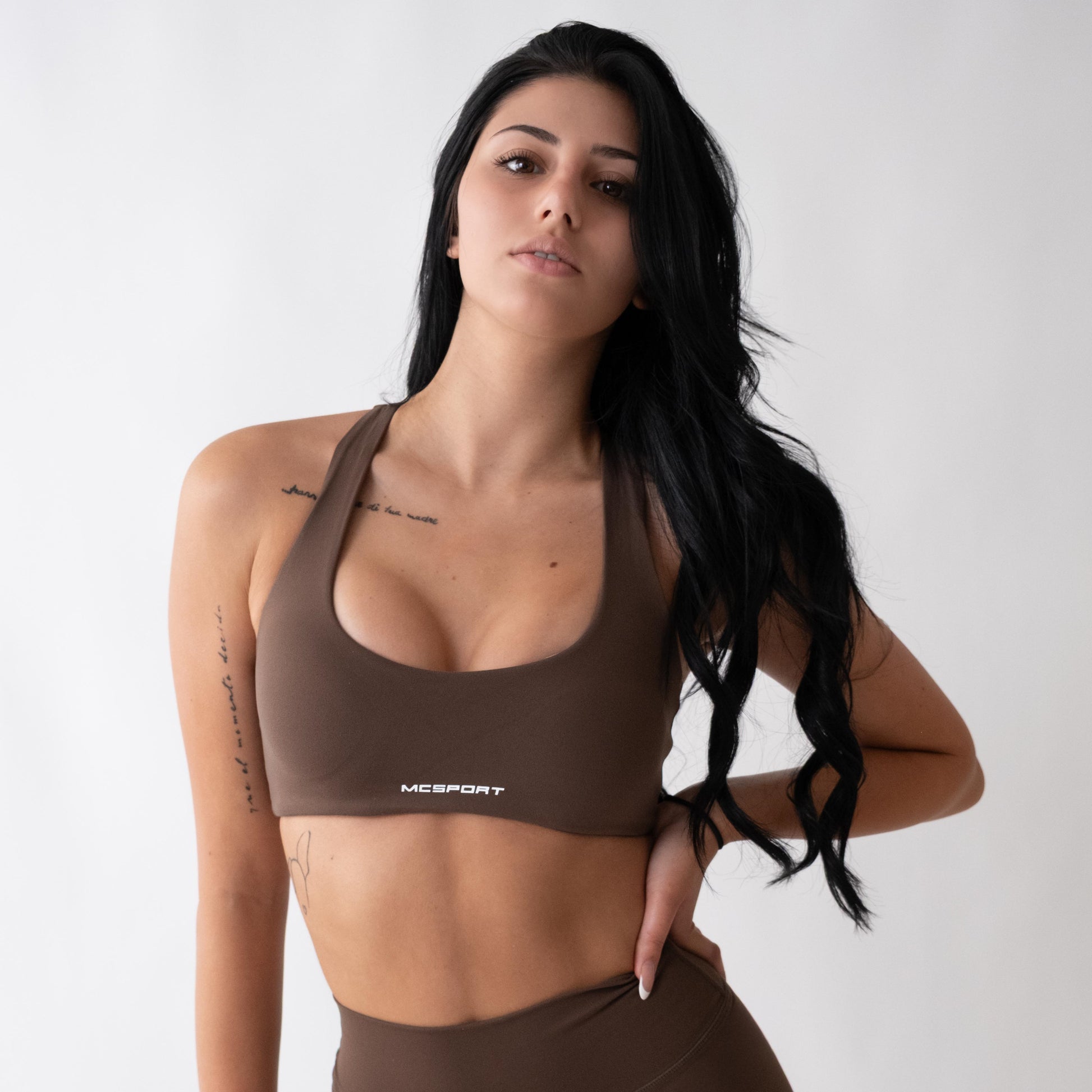 Top sportivo marrone da donna indossato con schiena olimpionica: tessuto elasticizzato, supporto confortevole e libertà di movimento per fitness, yoga, pilates e allenamenti.