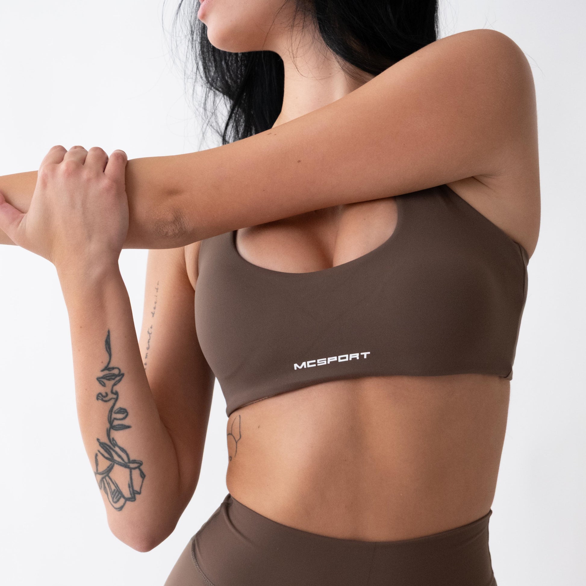 Top sportivo marrone da donna indossato con schiena olimpionica: tessuto elasticizzato, supporto confortevole e libertà di movimento per fitness, yoga, pilates e allenamenti.