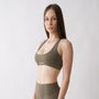 Top sportivo verde da donna indossato con schiena olimpionica: tessuto elasticizzato, supporto confortevole e libertà di movimento per fitness, yoga, pilates e allenamenti.
