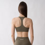 Top sportivo verde da donna indossato con schiena olimpionica: tessuto elasticizzato, supporto confortevole e libertà di movimento per fitness, yoga, pilates e allenamenti.