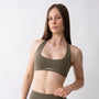 Top sportivo verde da donna indossato con schiena olimpionica: tessuto elasticizzato, supporto confortevole e libertà di movimento per fitness, yoga, pilates e allenamenti.