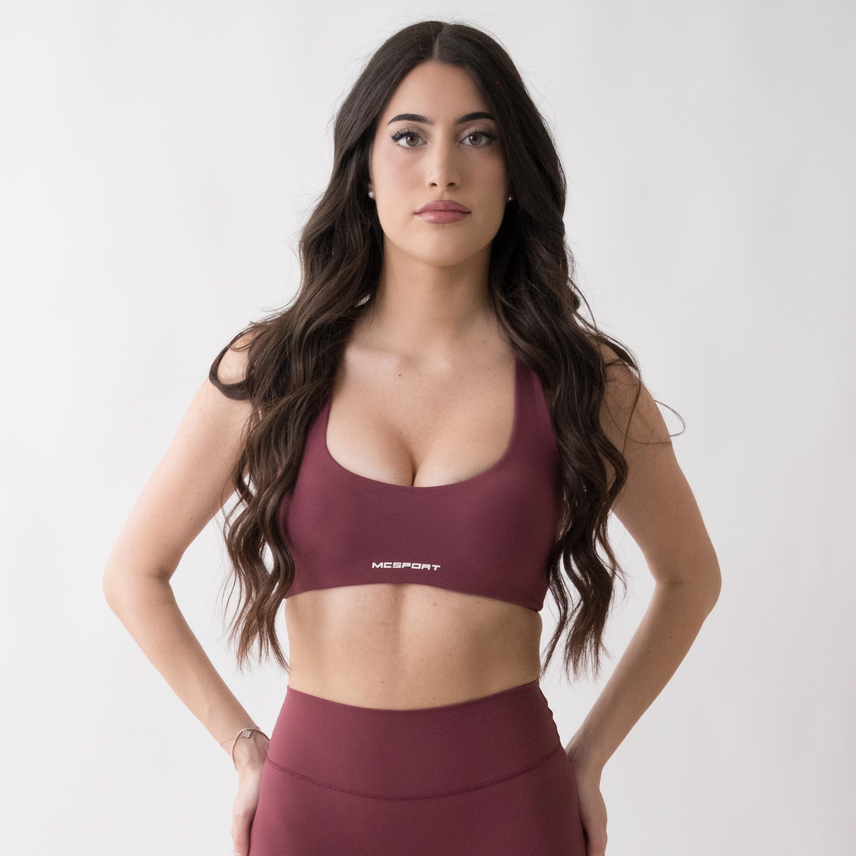 Top sportivo rosso da donna indossato con schiena olimpionica: tessuto elasticizzato, supporto confortevole e libertà di movimento per fitness, yoga, pilates e allenamenti.
