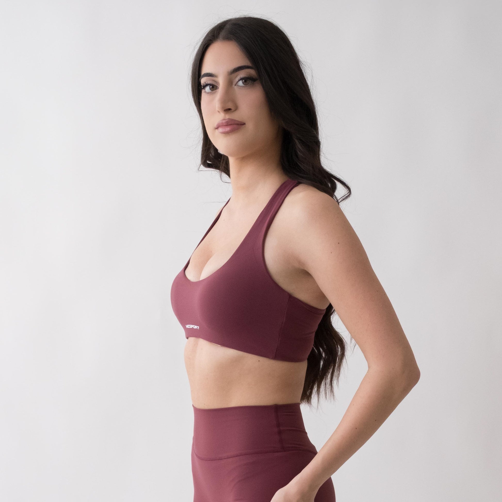 Top sportivo rosso da donna indossato con schiena olimpionica: tessuto elasticizzato, supporto confortevole e libertà di movimento per fitness, yoga, pilates e allenamenti.