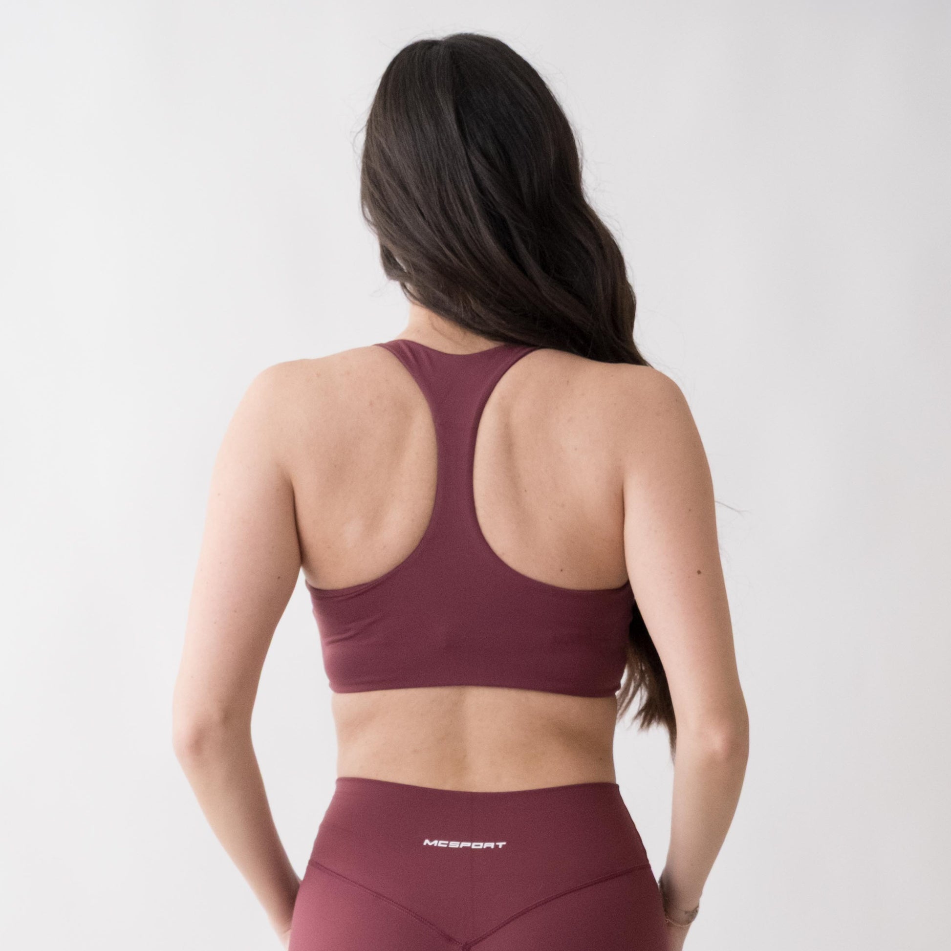 Top sportivo rosso da donna indossato con schiena olimpionica: tessuto elasticizzato, supporto confortevole e libertà di movimento per fitness, yoga, pilates e allenamenti.