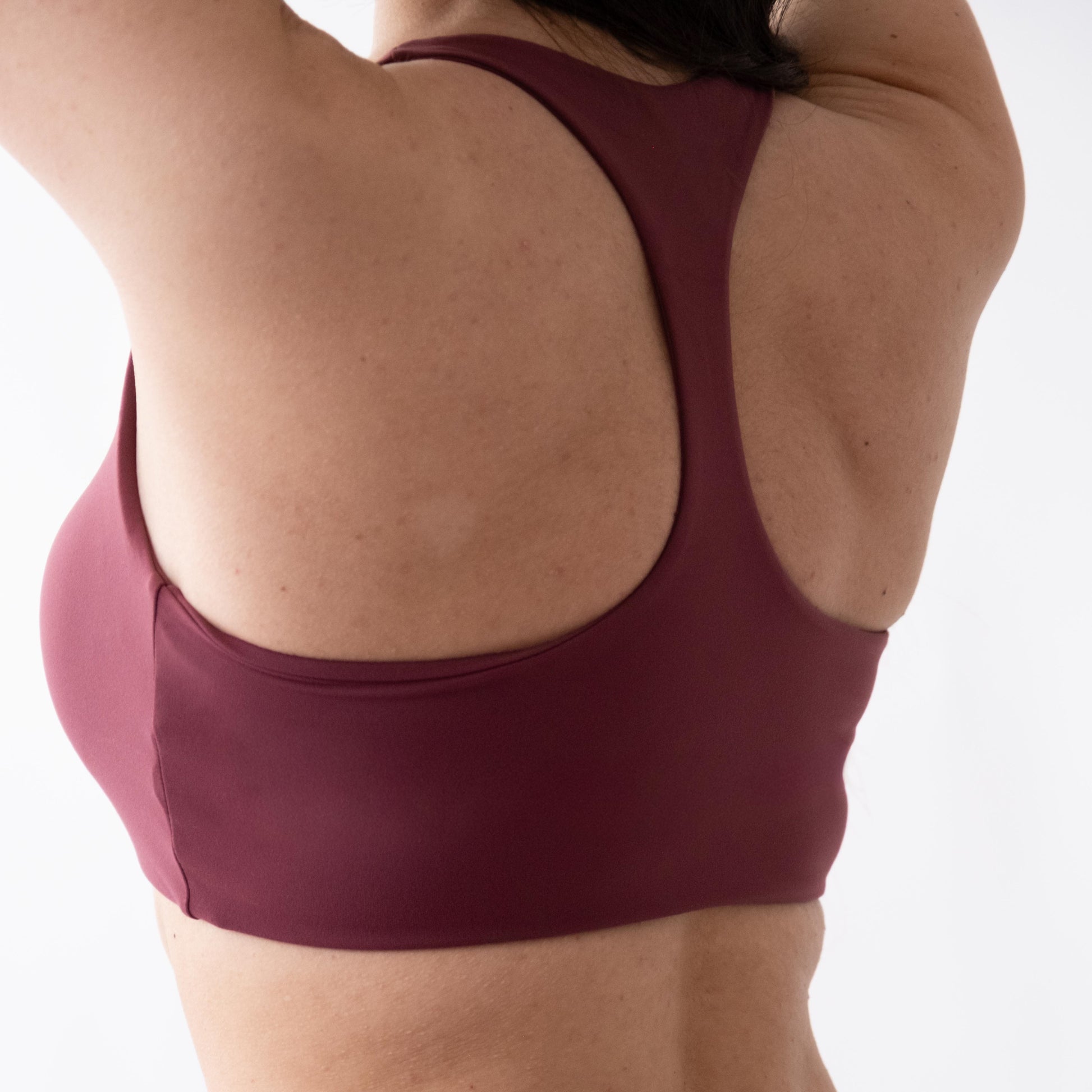 Top sportivo rosso da donna indossato con schiena olimpionica: tessuto elasticizzato, supporto confortevole e libertà di movimento per fitness, yoga, pilates e allenamenti.