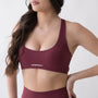 Top sportivo rosso da donna indossato con schiena olimpionica: tessuto elasticizzato, supporto confortevole e libertà di movimento per fitness, yoga, pilates e allenamenti.
