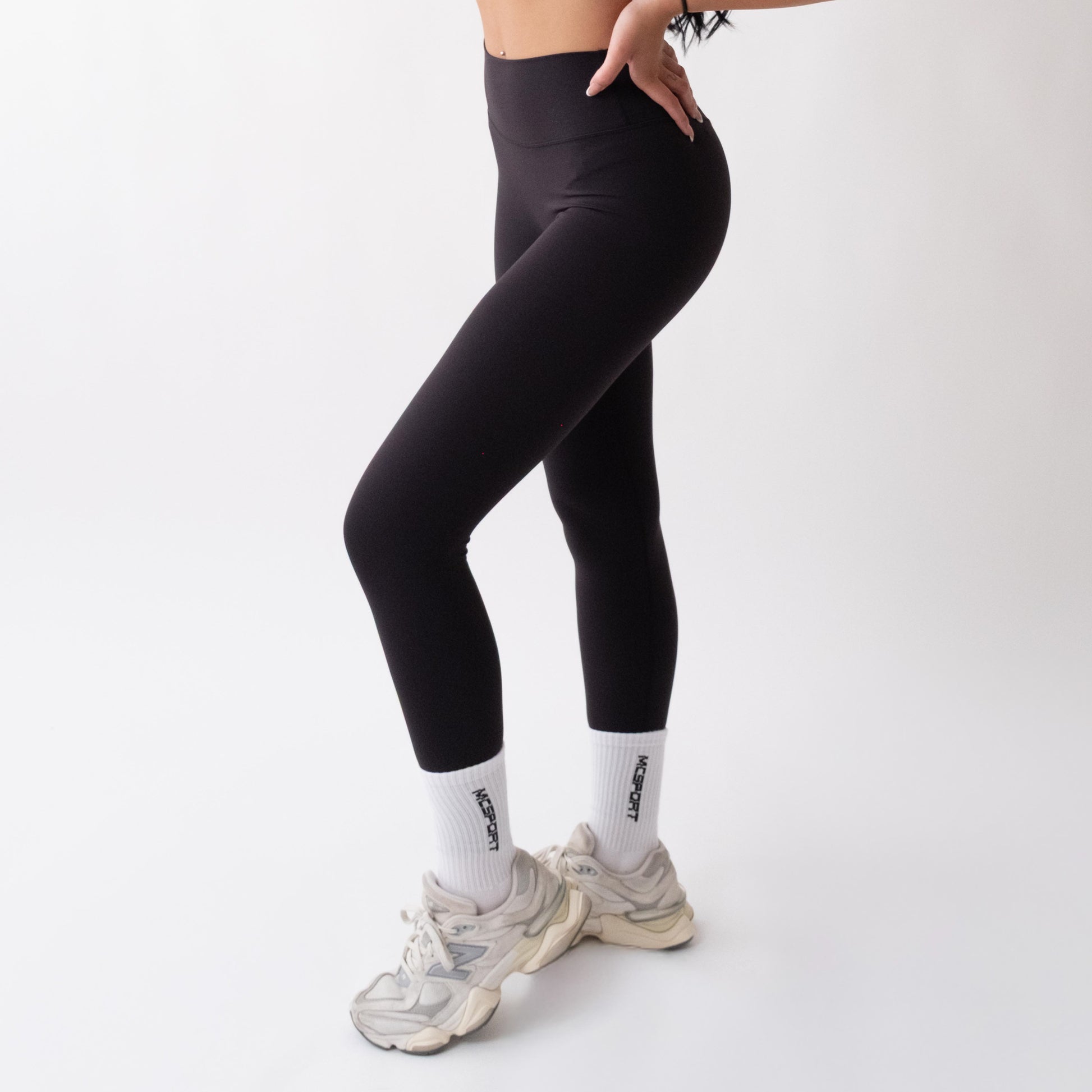 Leggings sportivi neri da donna indossati a vita alta: tessuto elasticizzato, morbido e confortevole per fitness, yoga, pilates e allenamenti di ogni intensità.