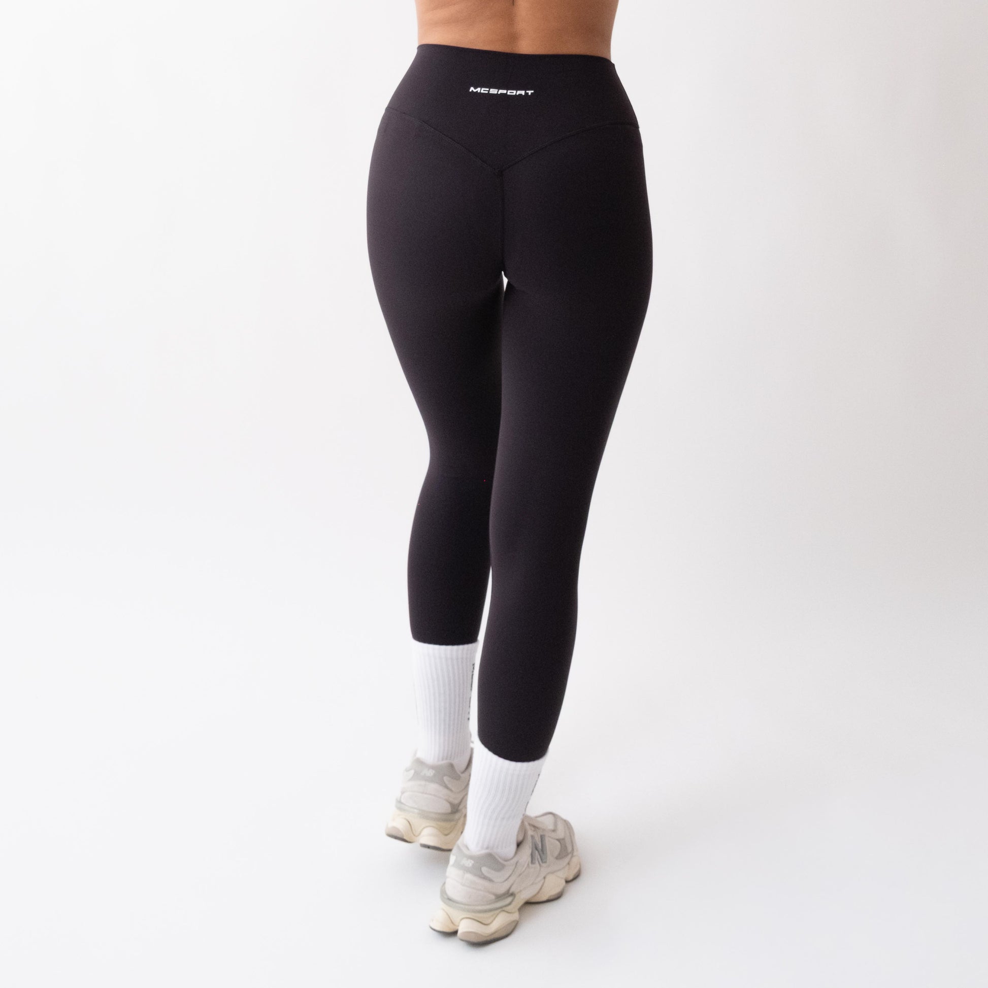 Leggings sportivi neri da donna indossati a vita alta: tessuto elasticizzato, morbido e confortevole per fitness, yoga, pilates e allenamenti di ogni intensità.