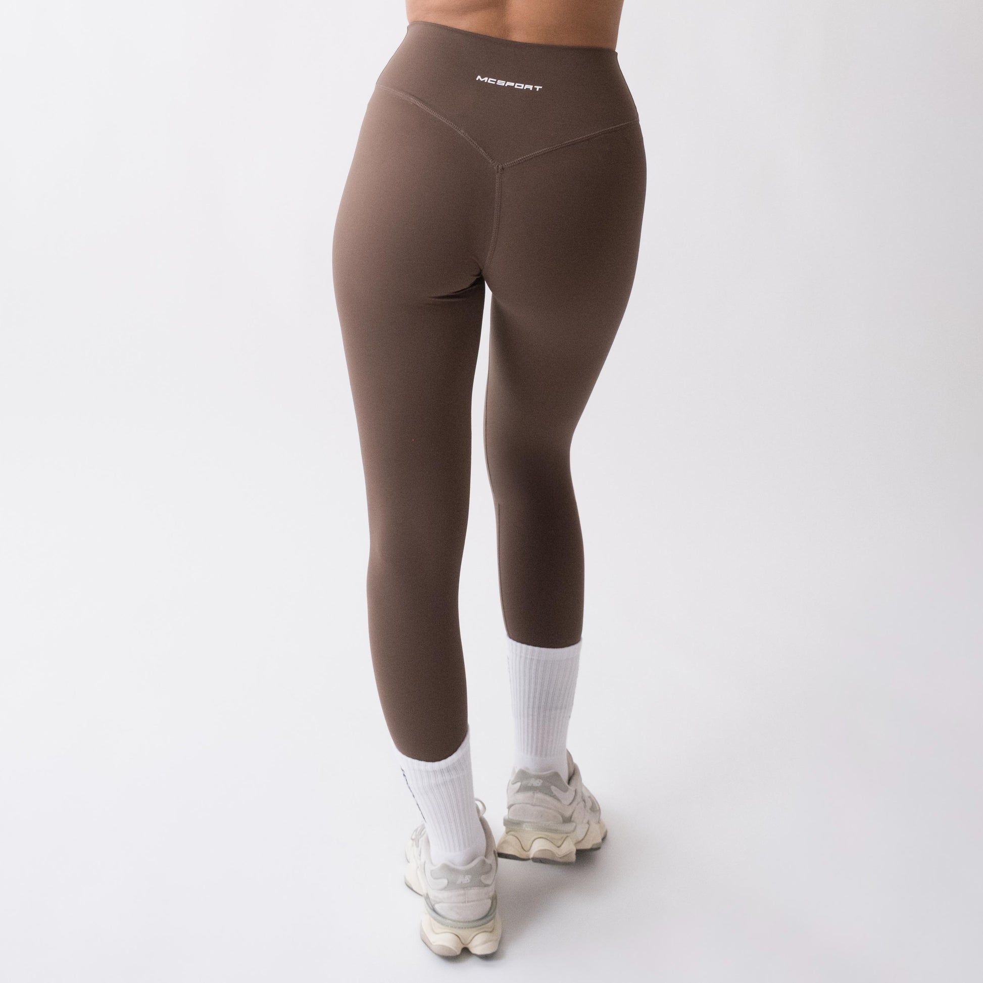 Leggings sportivi marroni da donna indossati a vita alta: tessuto elasticizzato, morbido e confortevole per fitness, yoga, pilates e allenamenti di ogni intensità.